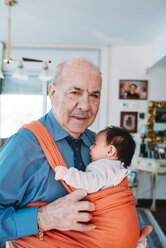 Portrait of great-grandfather carrying baby in a baby sling - GEMF01512