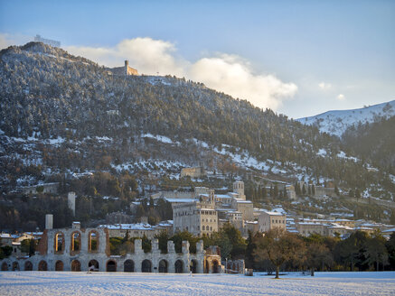 Italien, Umbrien, Gubbio, Palazzo dei Consoli und das römische Theater bei Sonnenaufgang im Winter - LOMF00532