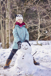 Porträt eines lächelnden Mädchens mit einem Schneemann - XCF00141