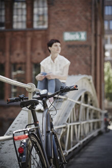 Germany, Hamburg, electric bicycle leaning against railing on a bridge - RORF00655