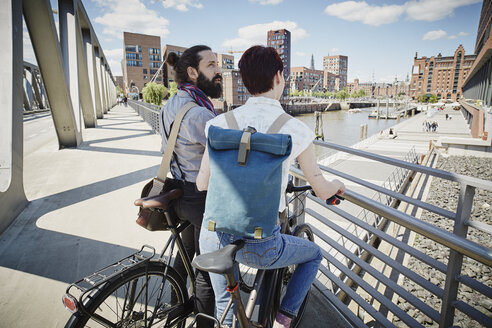 Germany, Hamburg, couple with electric bicycles on a bridge - RORF00663