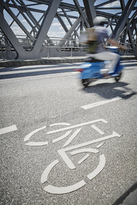 Deutschland, Hamburg, Mopedfahrer fährt neben dem Radweg auf einer Brücke - RORF00666