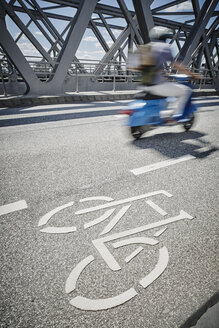 Germany, Hamburg, moped rider driving beside bicycle lane on a bridge - RORF00666