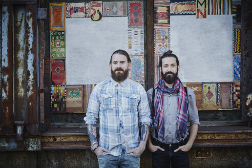 Portrait of two bearded friends standing side by side with hands in their pockets - RORF00676