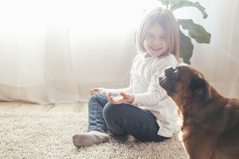 Glückliches kleines Mädchen mit ihrem Hund zu Hause - RTBF00701