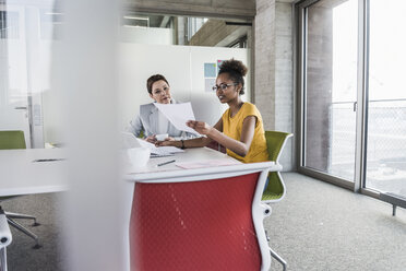 Two businesswomen discussing in conference room - UUF09989