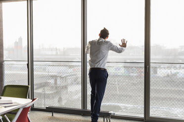 Young businessman looking out of window - UUF10053