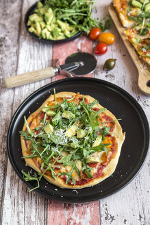 Vegetarische Pizza mit Avocado, Rucola, Tomaten und Parmesan auf dem Teller - SARF03216