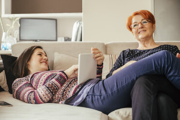 Erwachsene Tochter mit Mutter zu Hause am Tablet - ZEDF00529