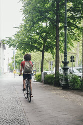 Young man riding bicycle on pavement - RTBF00704