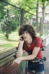 Young man with bicycle on the phone - RTBF00705