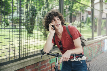 Junger Mann mit Fahrrad beim Telefonieren - RTBF00706