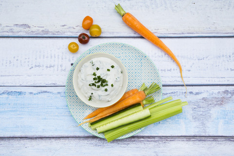 Schale mit Kräuter-Joghurt-Dip und Gemüsesticks auf dem Teller, lizenzfreies Stockfoto