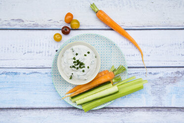 Bowl of herb yoghurt dip and vegetable sticks on plate - LVF05921