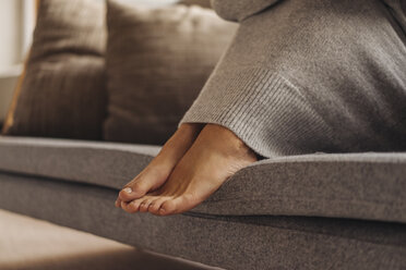 Nahaufnahme der Füße einer Frau auf der Couch sitzend - JOSF00636