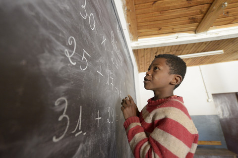 Madagaskar, Junge in der Grundschule von Fianarantsoa beim Rechnen an der Tafel, lizenzfreies Stockfoto