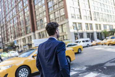 Businessman in the streets of Manhattan with yellow cab in background - GIOF02072