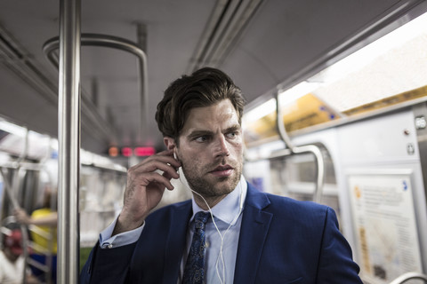 Geschäftsmann in der U-Bahn mit Smartphone, lizenzfreies Stockfoto