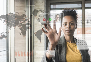 Young woman receiving a call on glass wall with world map in office - UUF10072