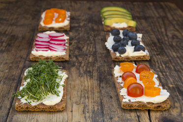 Crisp bread with cream cheese and avocado, radish, capsicum, cress, tomatos and blueberries - LVF05933