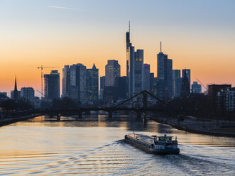 Deutschland, Frankfurt, Blick auf die Skyline mit Flößerbrücke und Main im Vordergrund in der Morgendämmerung - AMF05299