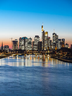 Deutschland, Frankfurt, Blick auf Skyline mit Flößerbrücke und Main im Vordergrund in der Dämmerung - AMF05304