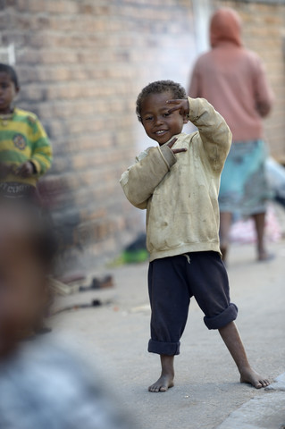 Madagaskar, Fianarantsoa, Obdachloser Junge macht Handzeichen, lizenzfreies Stockfoto