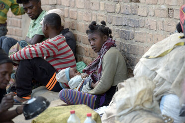 Madagaskar, Fianarantsoa, Obdachlose Mutter sitzt auf dem Boden - FLKF00774