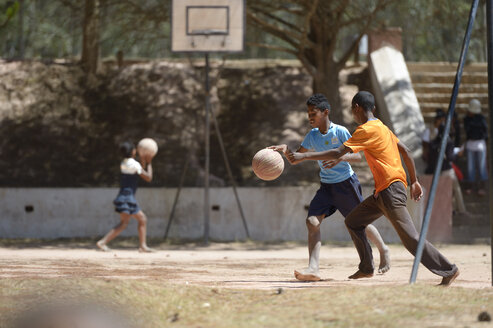 Madagaskar, Fianarantsoa, Junge spielt Fußball auf dem Schulhof - FLKF00777