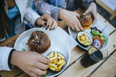 Women's hands eating Hamburgers and French fries - KIJF01302