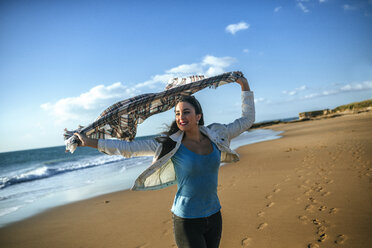 Junge Frau mit Decke im Wind am Strand - KIJF01313