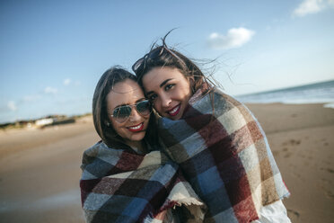 Porträt von zwei mit einer Decke bedeckten Frauen am Strand - KIJF01314