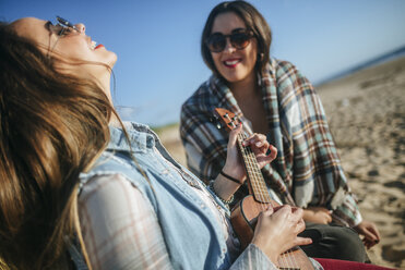 Woman playing ukulele while her friend watching her - KIJF01318