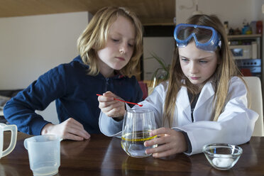 Zwei Kinder benutzen einen Chemiebaukasten zu Hause - SARF03223