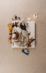 Frau schläft mit ihren Hunden im Bett, auf der Kante liegend - JOSF00655