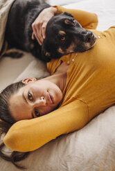 Frau im Bett liegend mit ihrem Hund - JOSF00660