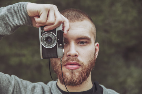 Portrait of bearded man taking photo with vintage camera stock photo