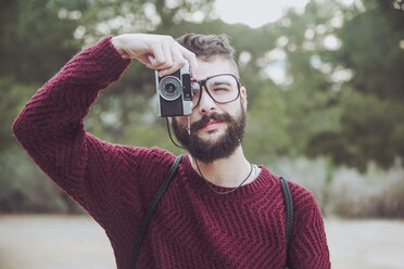 Porträt eines bärtigen Mannes mit Brille, der mit einer alten Kamera fotografiert - RTBF00720