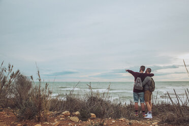 Back view of young gay couple looking at the sea - RTBF00740