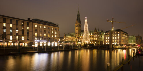 Germany, Hamburg, illuminated Christmas tree and lighted town hall with Binnenalster in the foreground - WIF03403