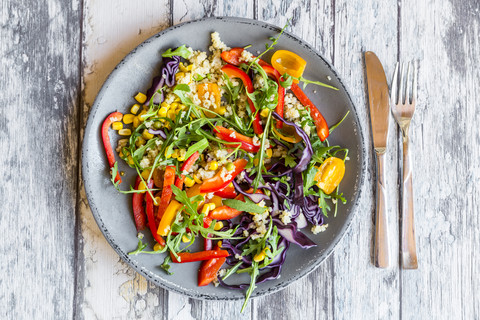 Teller mit Regenbogensalat mit Bulgur, Rucola und verschiedenen Gemüsesorten, lizenzfreies Stockfoto