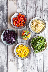 Glas Regenbogensalat mit Bulgur, Rucola und verschiedenen Gemüsesorten und Schalen mit Zutaten - SARF03240