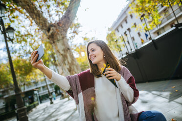 Junge Frau in Sevilla macht Selfie und isst Pommes frites - KIJF01340