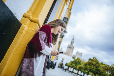 Junge Frau in Sevilla benutzt ihr Smartphone - KIJF01345