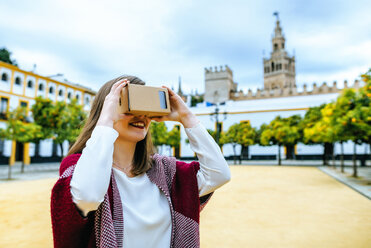 Junge Frau in Sevilla schaut durch eine VR-Brille - KIJF01347