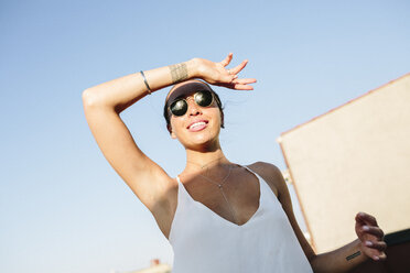 Junge Frau mit Sonnenbrille, die die Augen vor der Sonne schützt - GIOF02126