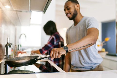 Junges Paar beim gemeinsamen Kochen zu Hause, lizenzfreies Stockfoto