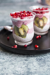 Zwei Gläser Chia-Pudding mit herzförmigen Kiwi-Scheiben und Granatapfelkernen - SARF03251