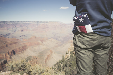 USA, Grand Canyon, Mann mit amerikanischer Flagge in seiner Tasche, Teilansicht, lizenzfreies Stockfoto