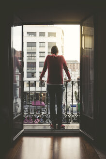 Mann auf einem Balkon in der Stadt bei Sonnenuntergang - EPF00388